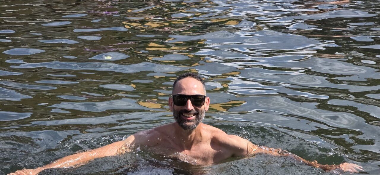 Hombre sonriendo mientras nada en un lago