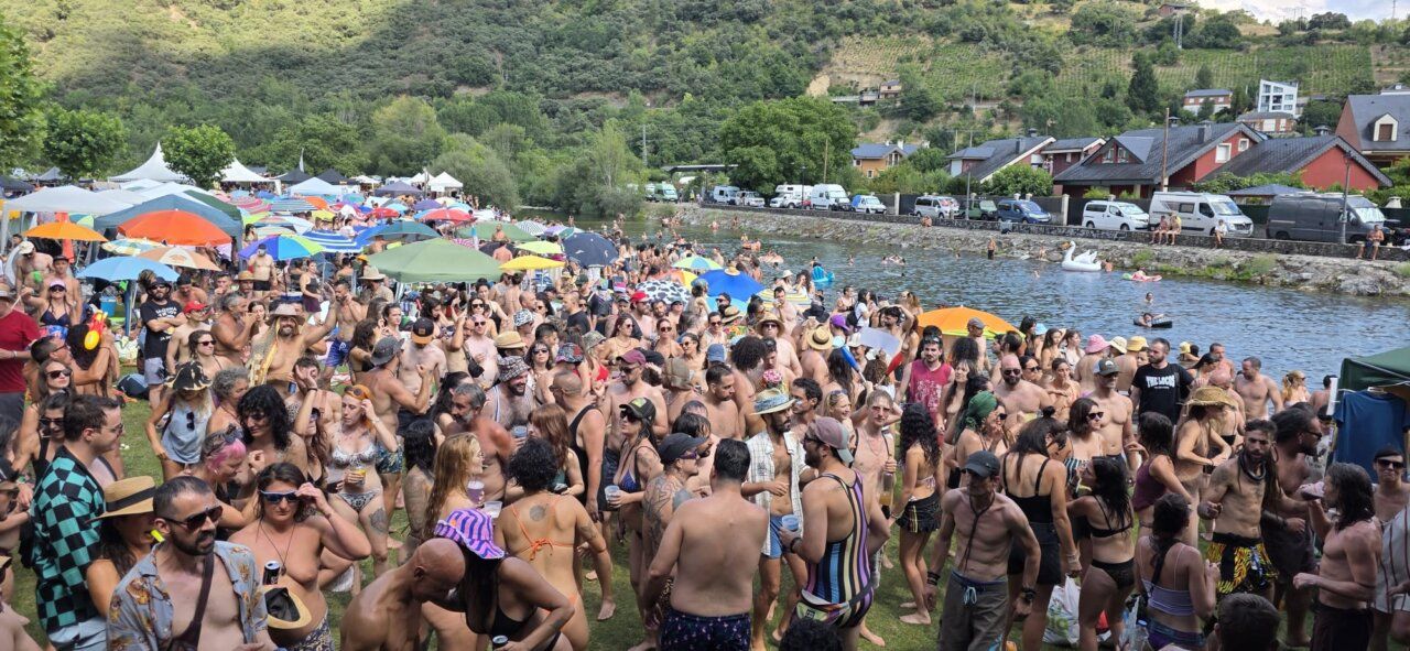Multitud de personas disfrutando en un festival junto al río