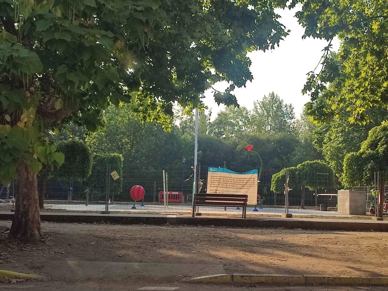 Zona de juegos de agua en el parque de La Concordia con una estructura de juego y un cartel.