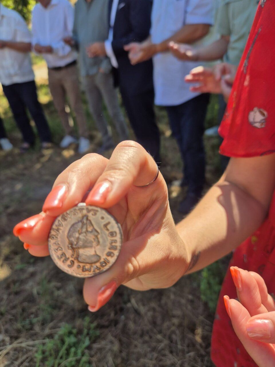 Persona sosteniendo una moneda antigua en Las Médulas