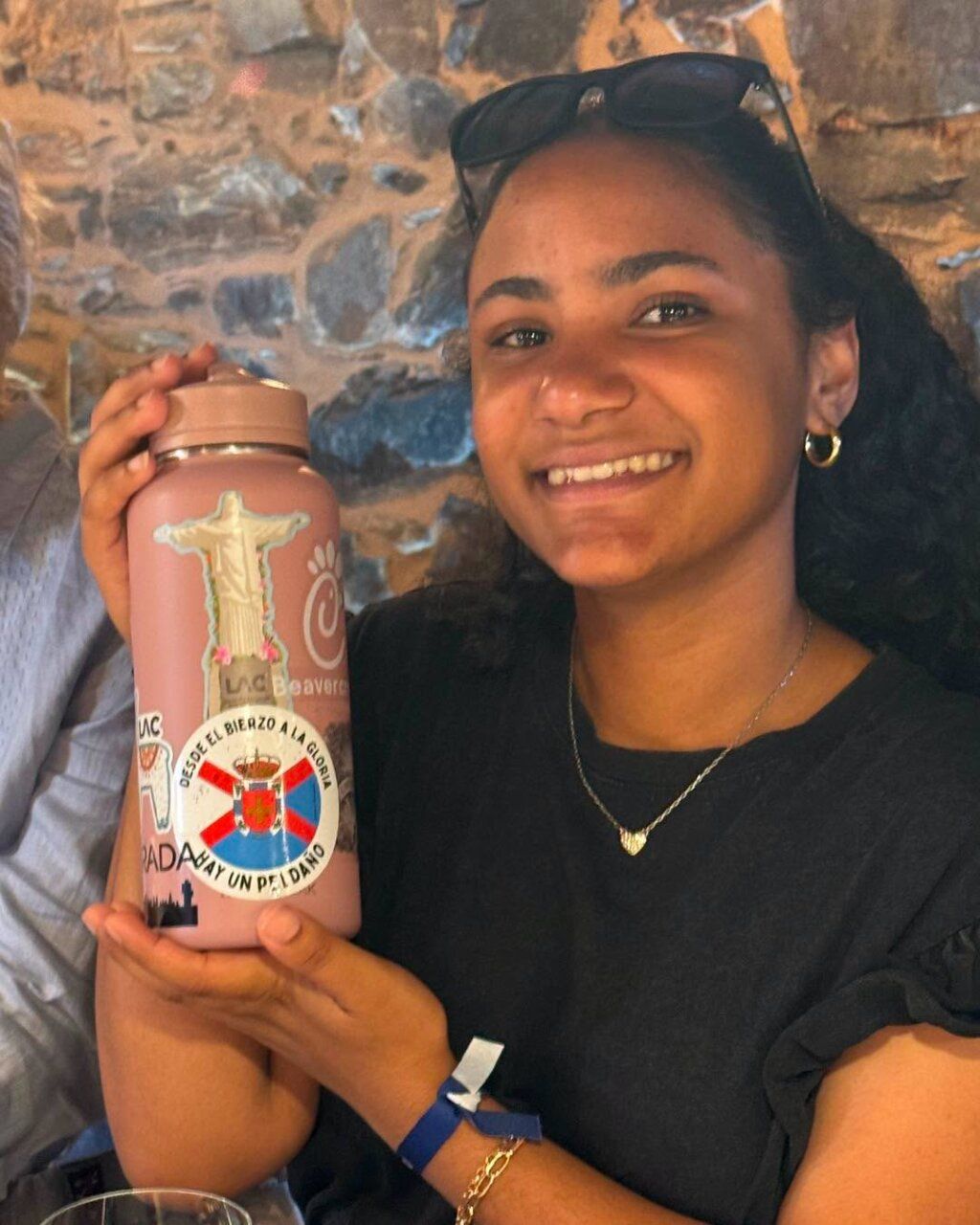 Joven sosteniendo una botella decorada en evento cultural en Magaz de Arriba