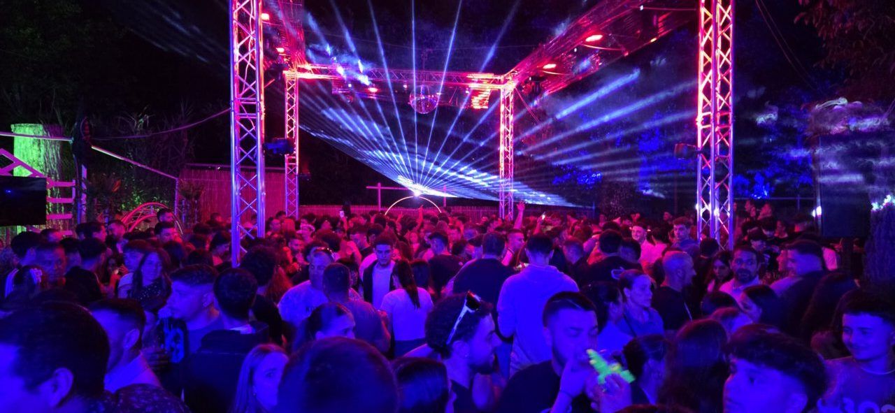 Ambiente festivo en La Mala Vida Terrace Club con luces y gente bailando.