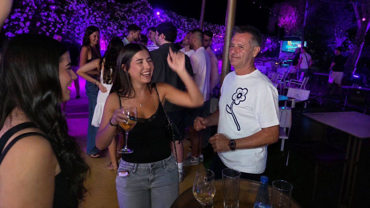 Grupo de personas disfrutando en una fiesta nocturna con luces de colores