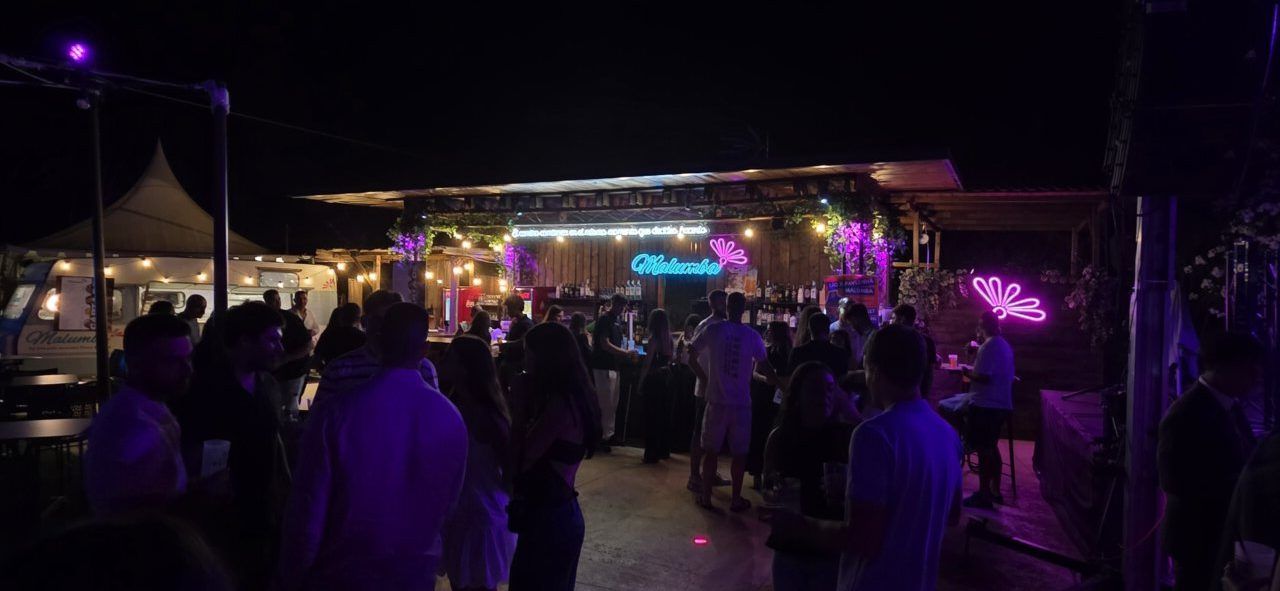 Ambiente festivo en el bar Malumba con luces de neón