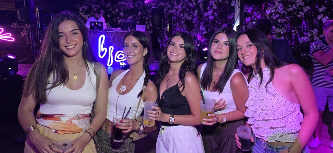 Grupo de amigas disfrutando en una fiesta con bebidas en mano