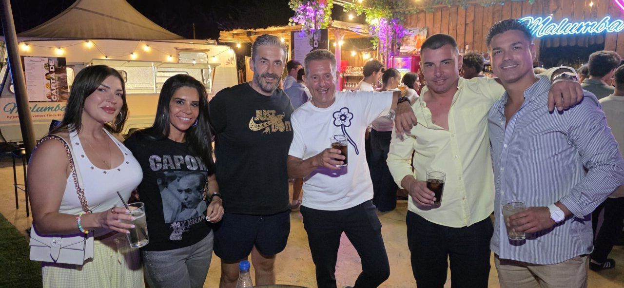 Grupo de amigos disfrutando en Malumba con bebidas en mano