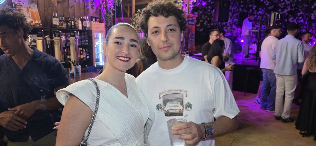 Pareja sonriente en un bar durante una fiesta nocturna