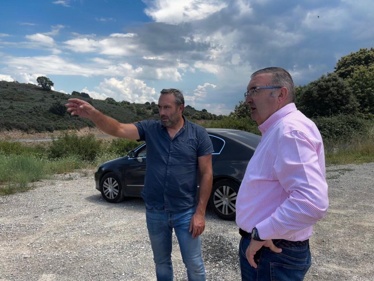 Dos hombres discutiendo sobre la mejora de la carretera en Corullón