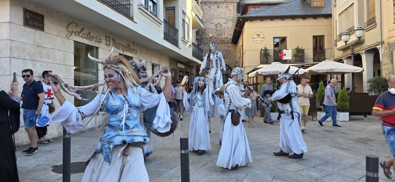 Actores disfrazados en un mercado medieval con música y danza