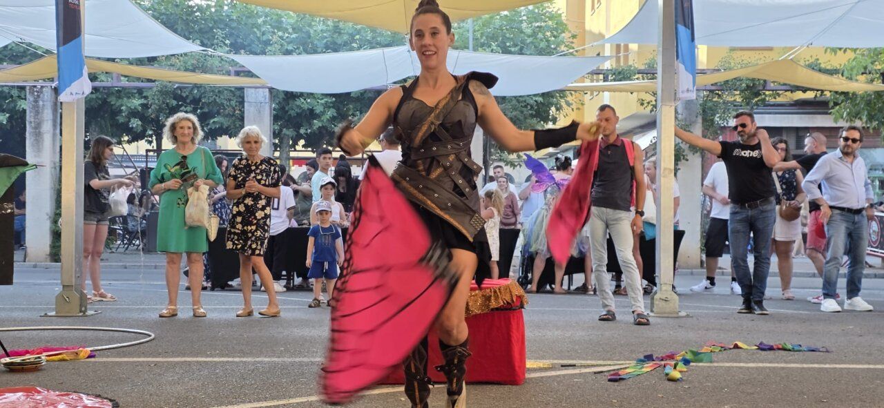 Artista de mercado medieval bailando con pañuelos de colores