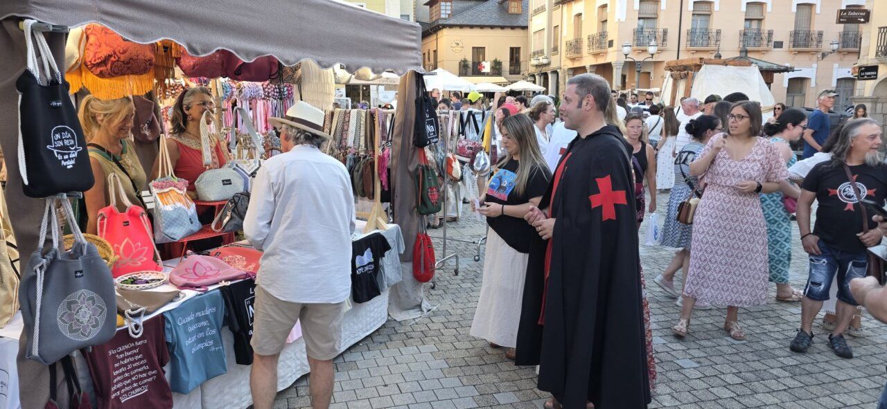 Personas en un mercado medieval con productos artesanales