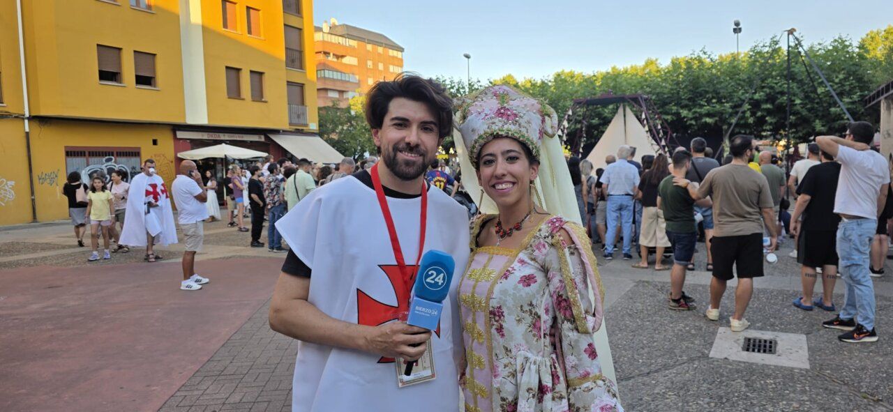 Pareja vestida con trajes medievales en un mercado medieval