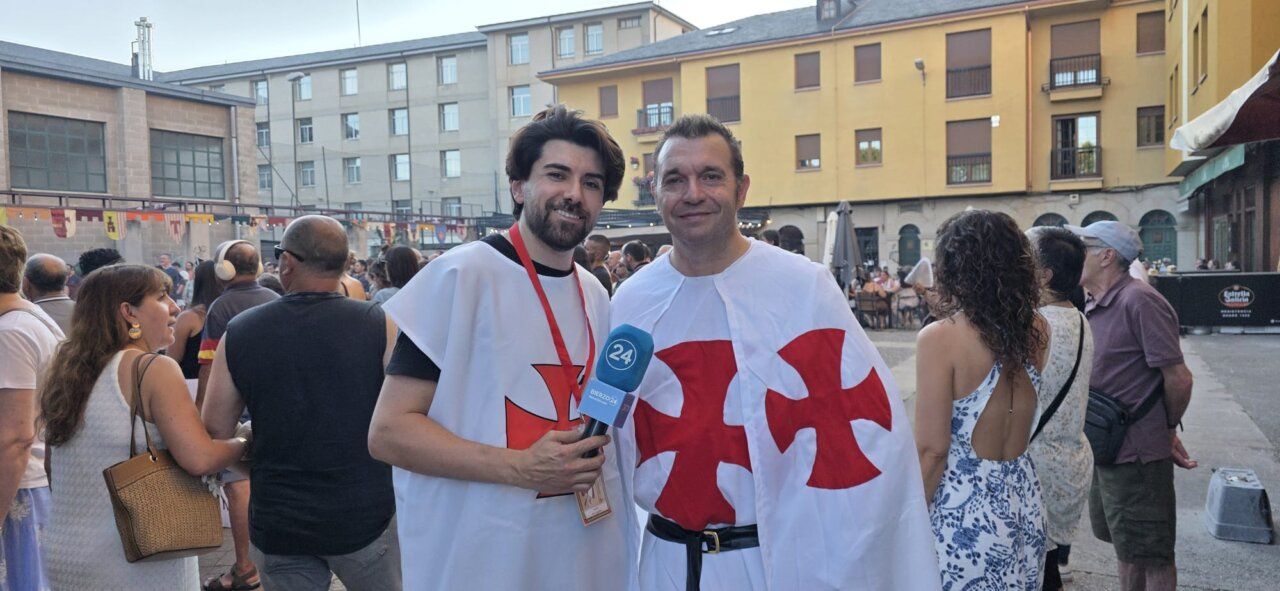 Dos hombres vestidos con trajes medievales en un mercado medieval