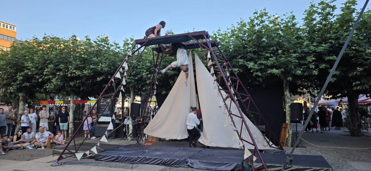 Actuación acrobática en un mercado medieval con público atento