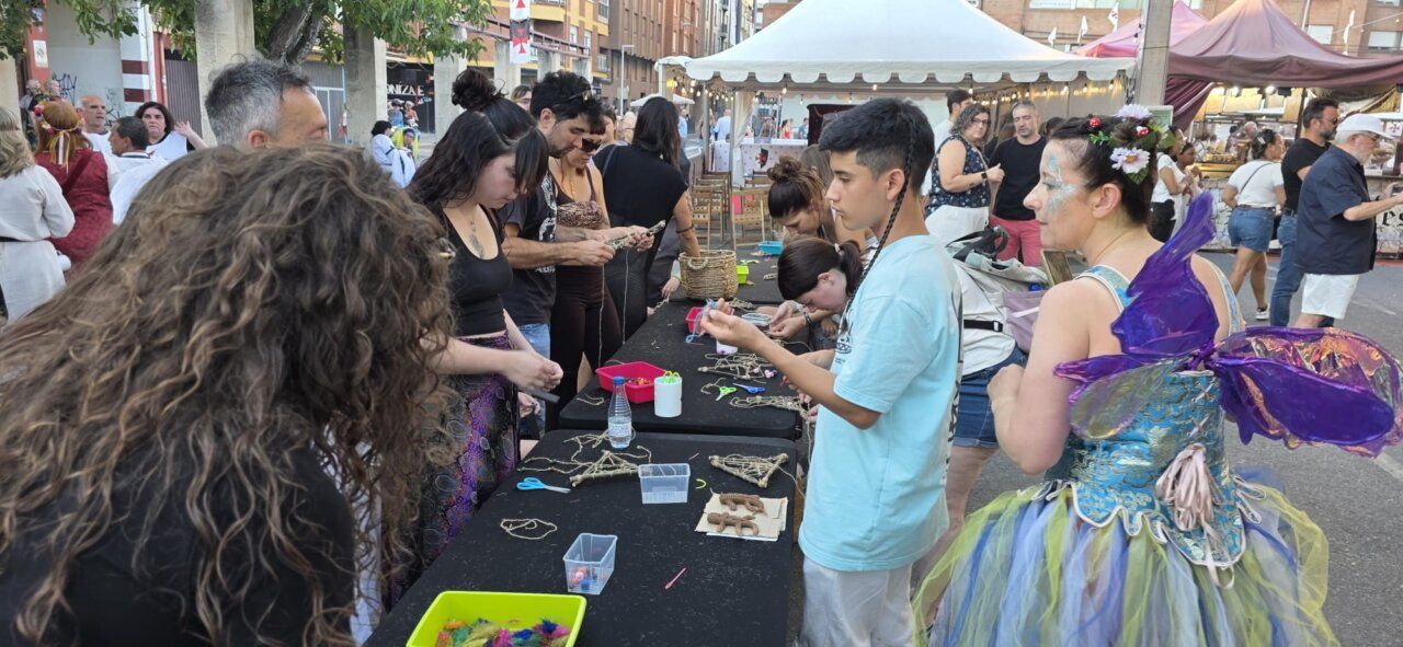 Grupo de personas participando en un taller de artesanía en un mercado medieval