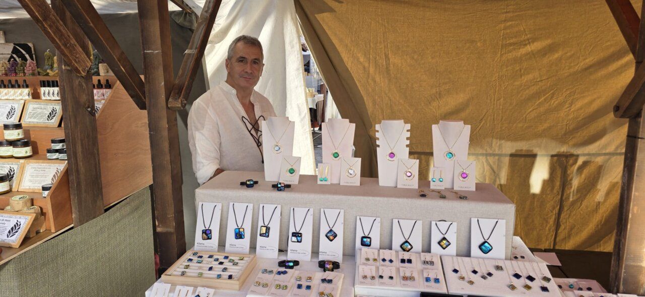 Vendedor en un mercado medieval mostrando joyas artesanales