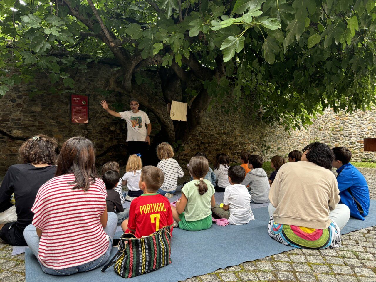 Niños escuchando una historia bajo un higuera en el Museo del Bierzo