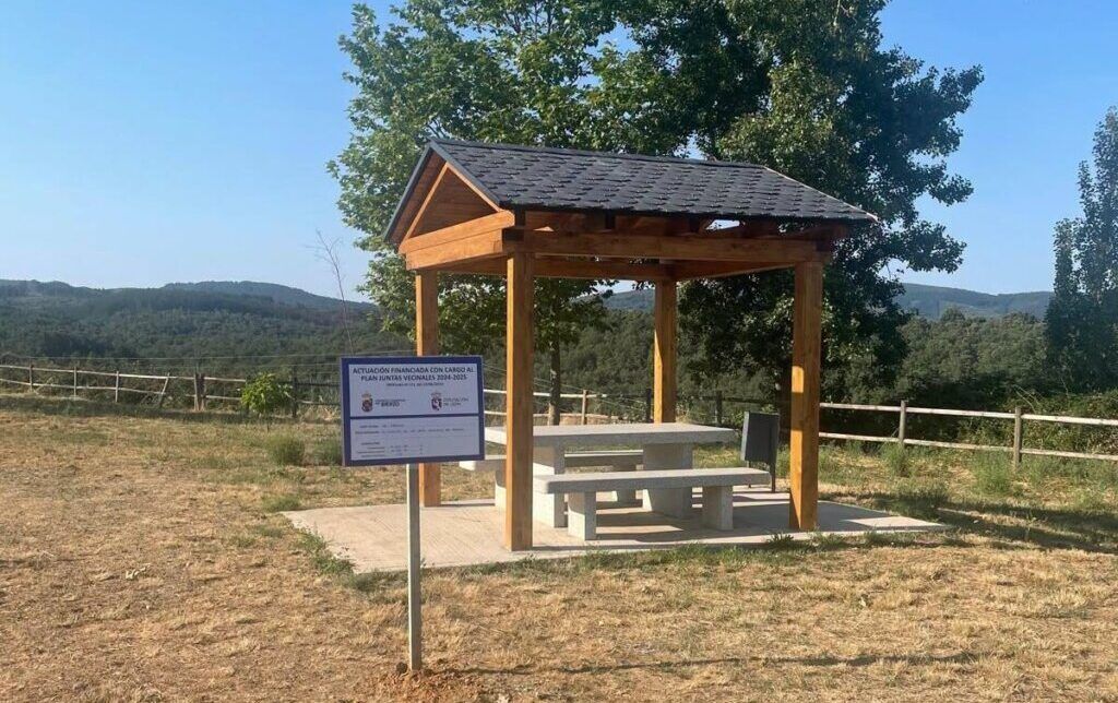 Área de descanso en El Rebollín, Fabero, con mesa y bancos de piedra.