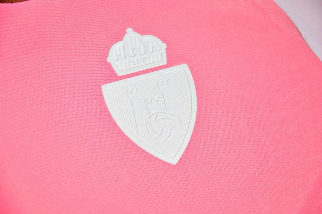 Detalle de la nueva camiseta rosa de la SD Ponferradina con escudo