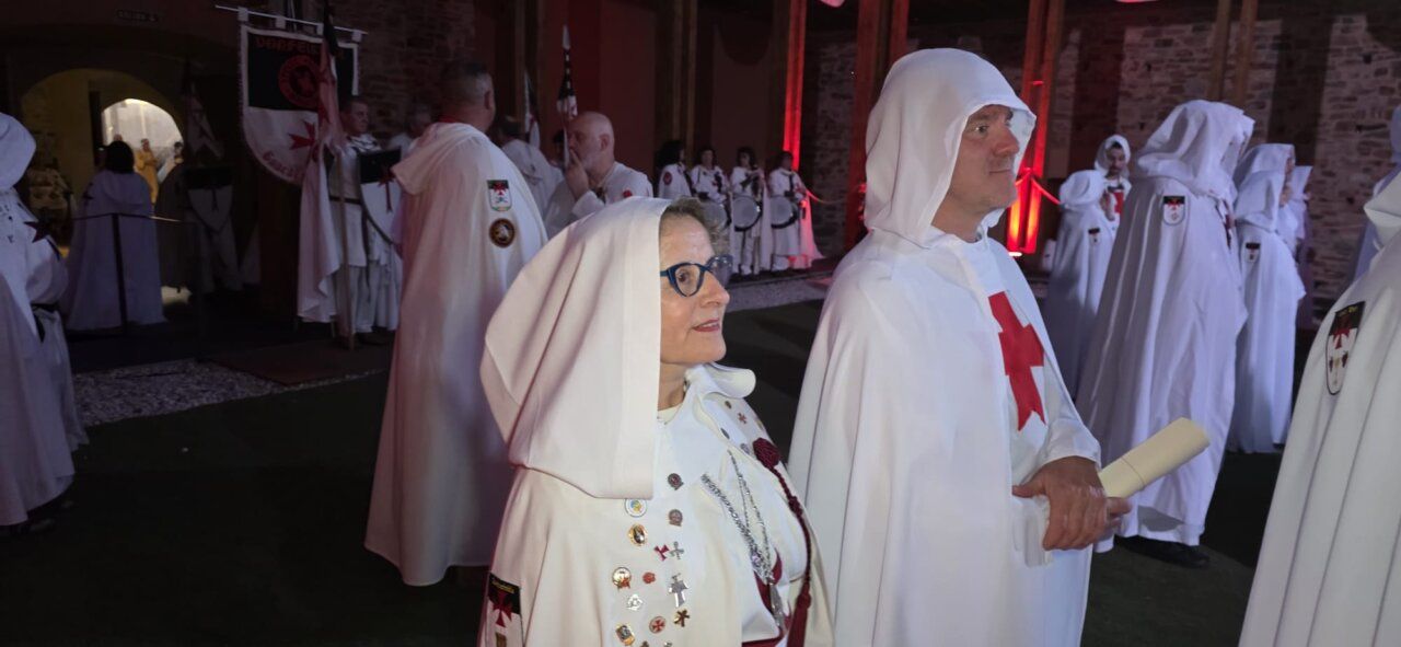 Ceremonia de ordenación templaria con participantes en túnicas blancas