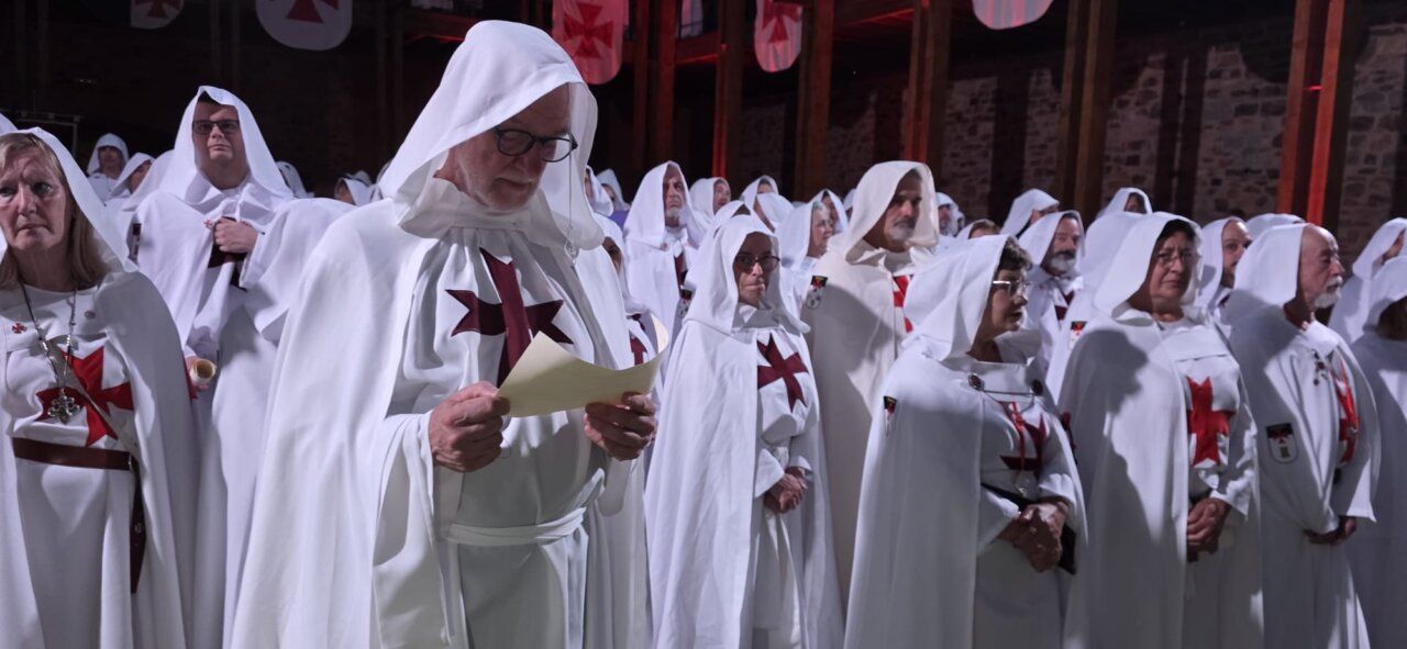 Ceremonia de ordenación templaria con participantes en túnicas blancas