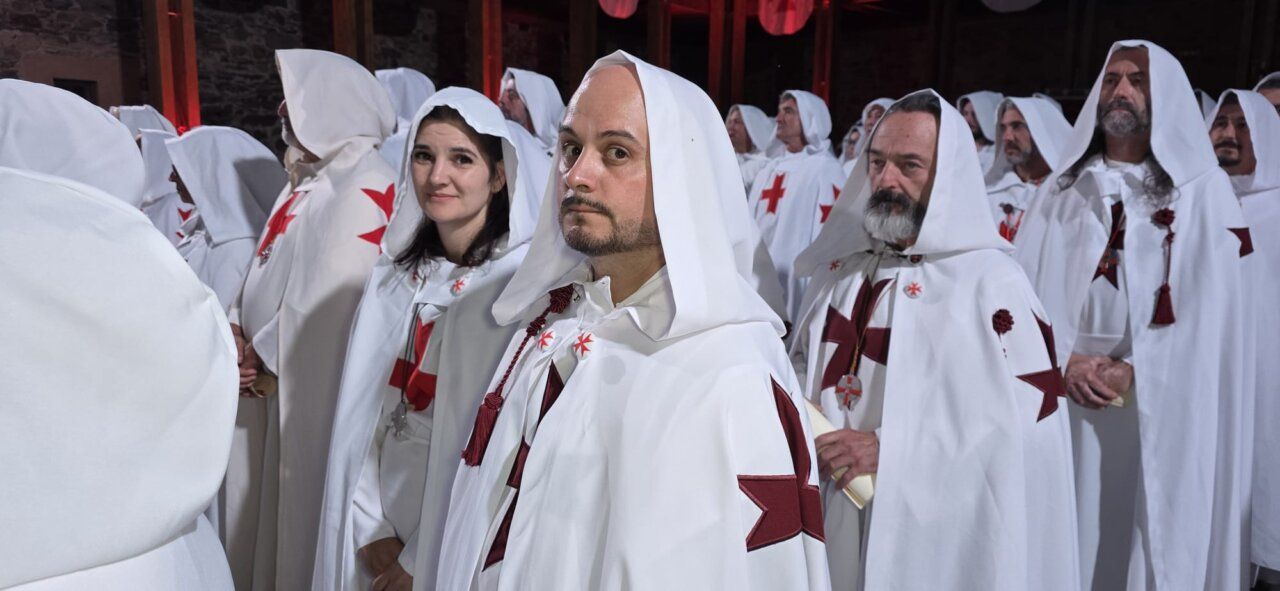 Ceremonia de ordenación templaria con participantes en túnicas blancas