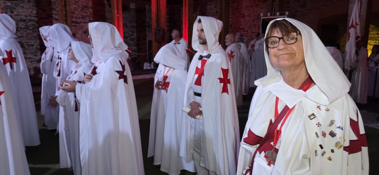 Ceremonia de ordenación templaria con participantes en túnicas blancas