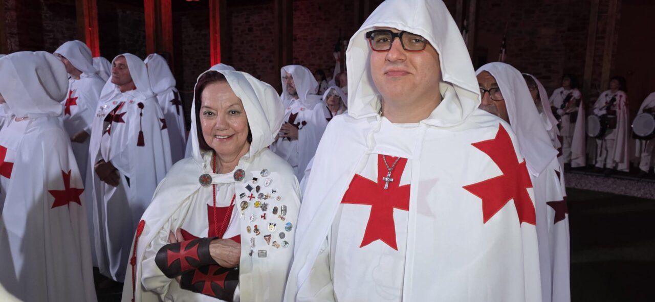 Participantes en la ordenación templaria con capas blancas y cruces rojas