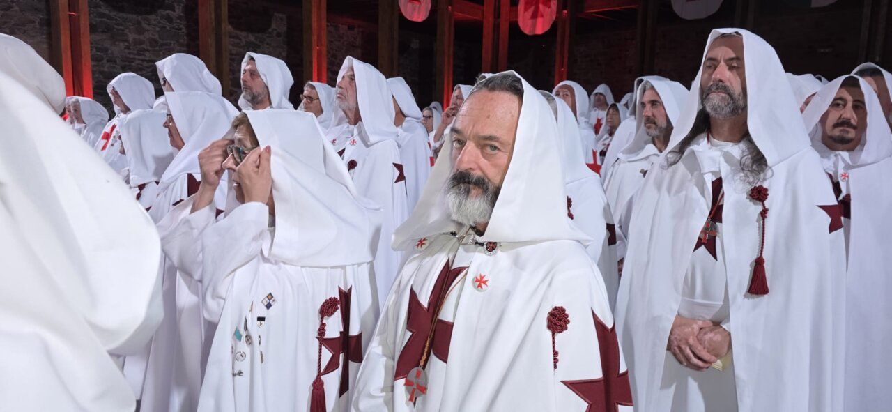 Ceremonia de ordenación templaria con participantes en túnicas blancas