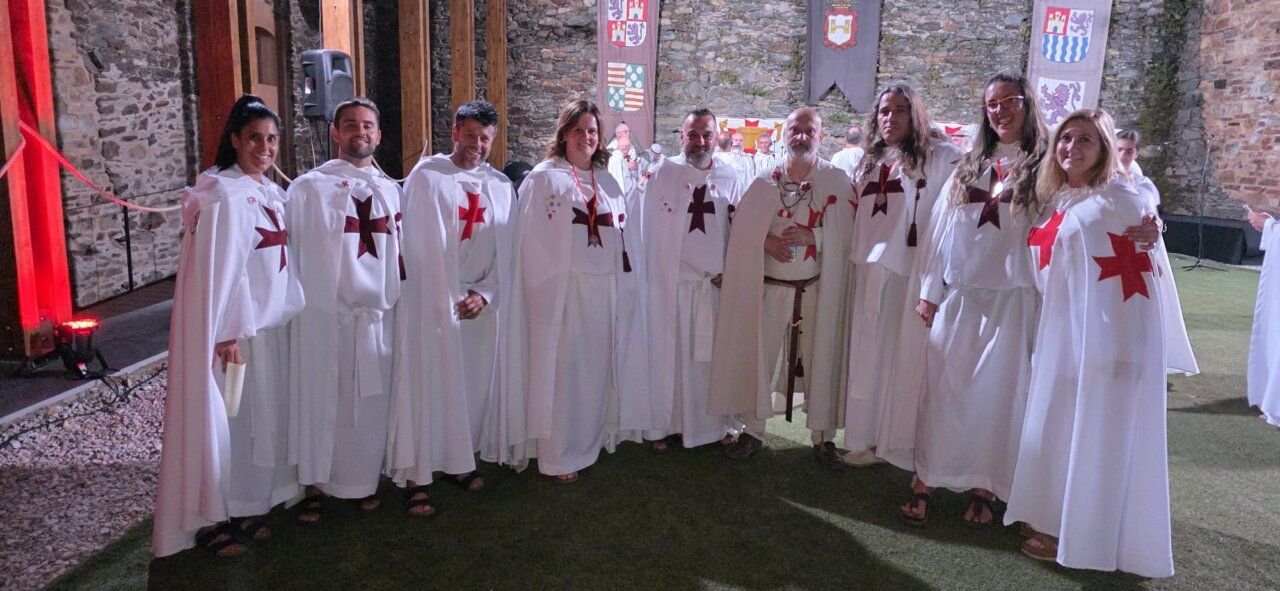 Grupo de personas vestidas con túnicas blancas y cruces rojas en ceremonia templaria
