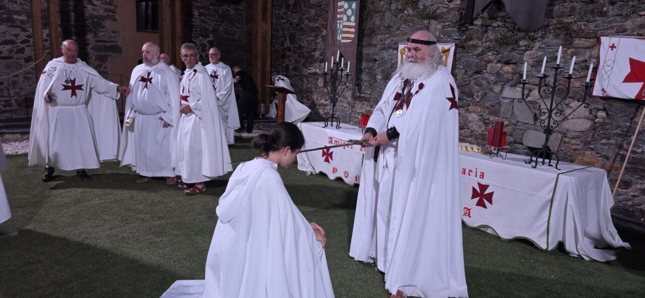 Ceremonia de ordenación templaria con participantes en túnicas blancas