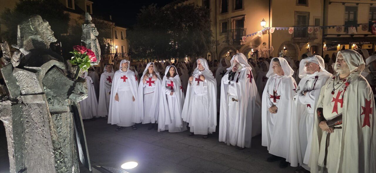 Grupo de personas vestidas de templarios en una ceremonia nocturna
