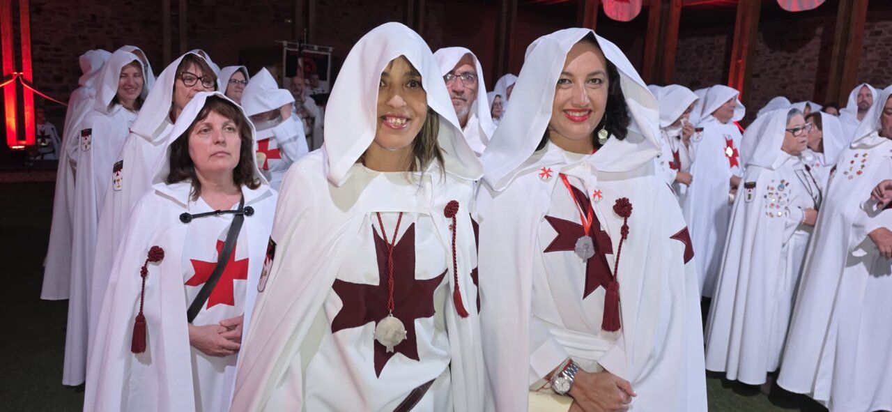 Participantes en la ceremonia de ordenación templaria con capas blancas y cruces rojas