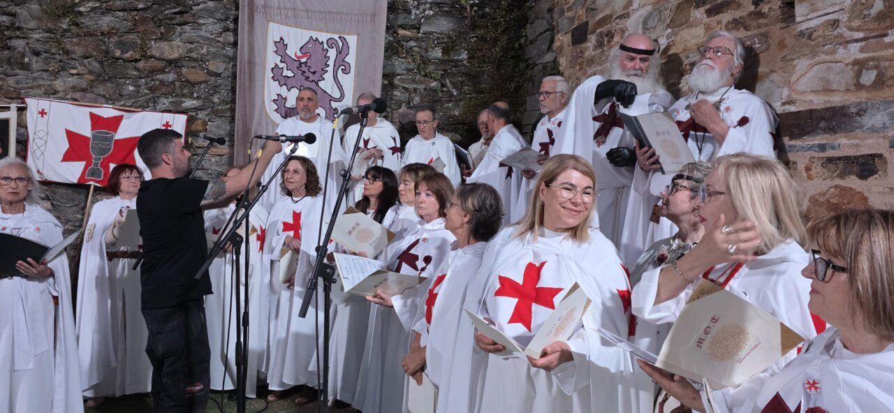 Grupo de personas vestidas con túnicas blancas y cruces rojas en un evento