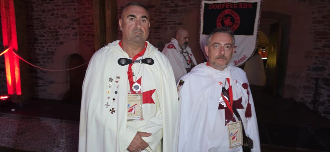 Dos hombres con capas y medallas en un evento templario