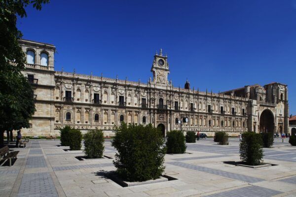 Vista del Parador de San Marcos en León, España, con cielo azul.