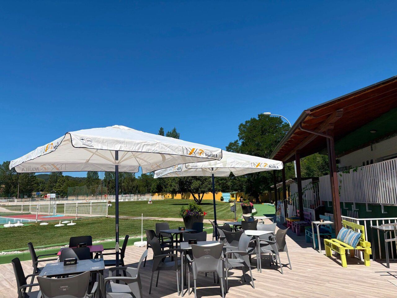 Vista de las piscinas municipales de Toreno y Matarrosa con sombrillas y mesas