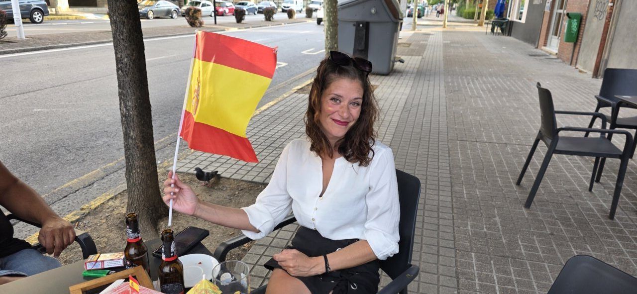 Mujer sosteniendo una bandera de España en un bar durante el Mundial
