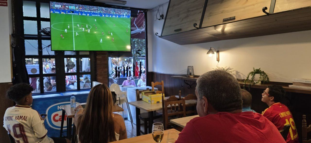 Aficionados viendo el partido España vs Portugal en un bar
