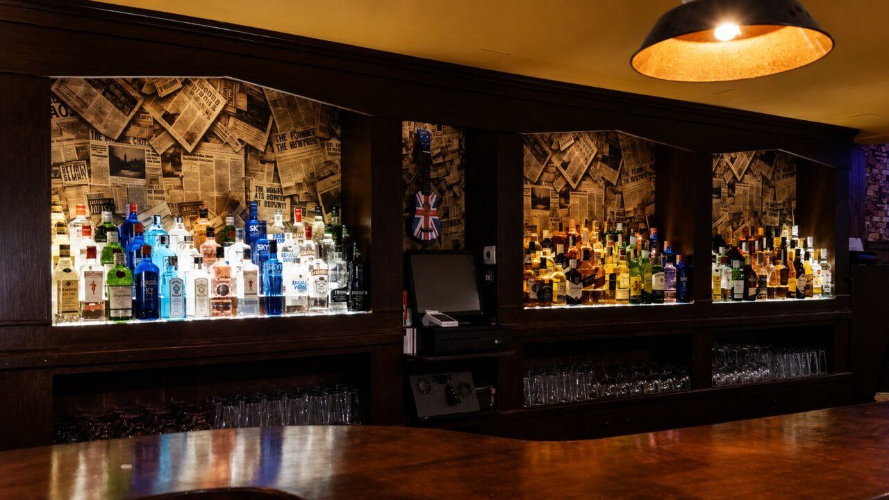 Barra del pub Lennon Club con botellas de licor y decoración vintage.