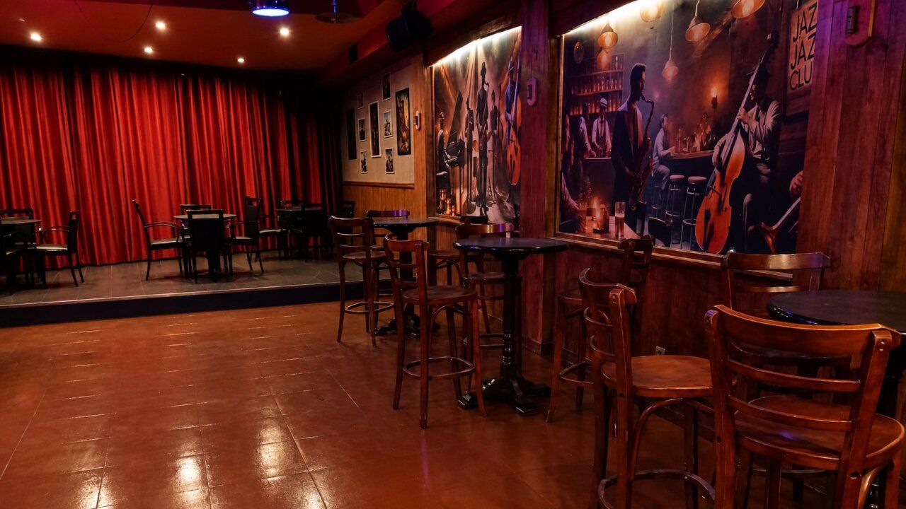 Interior del pub Lennon Club en Ponferrada con mesas y escenario