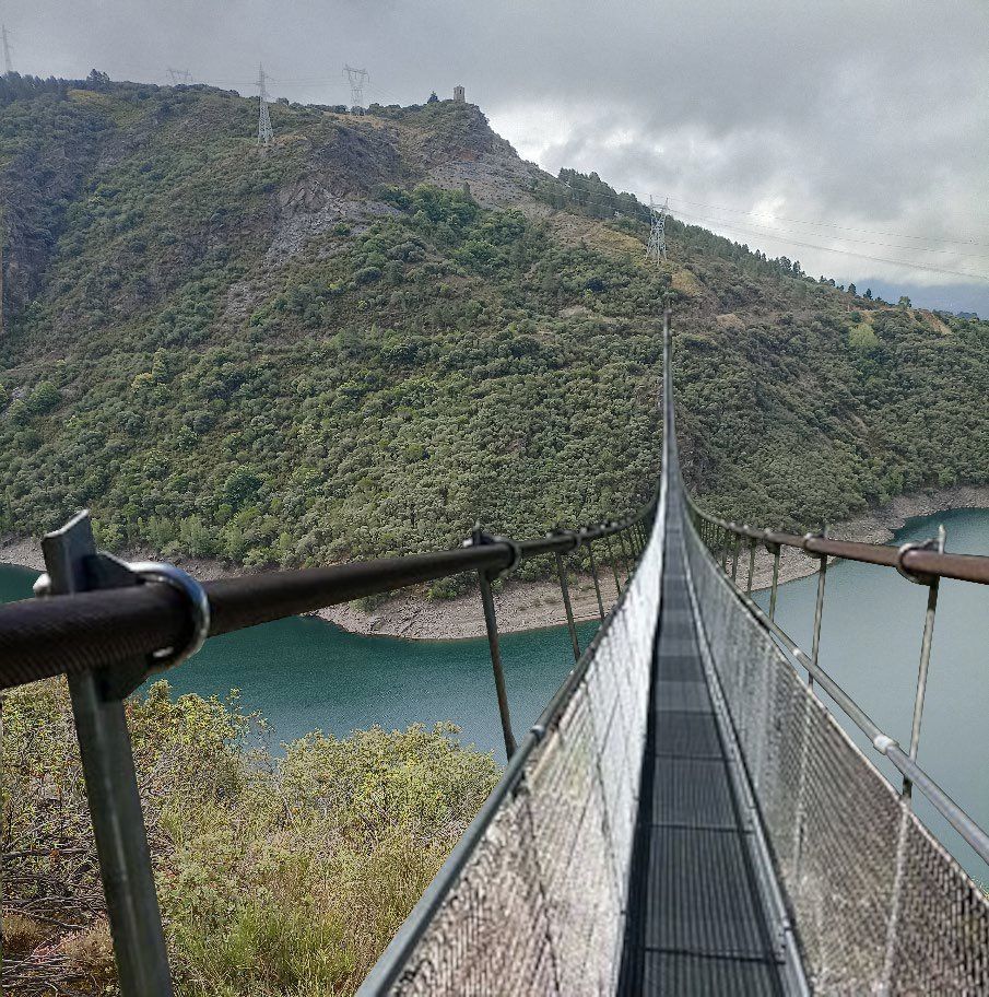 Vista del puente colgante sobre el embalse de Bárcena en un día nublado