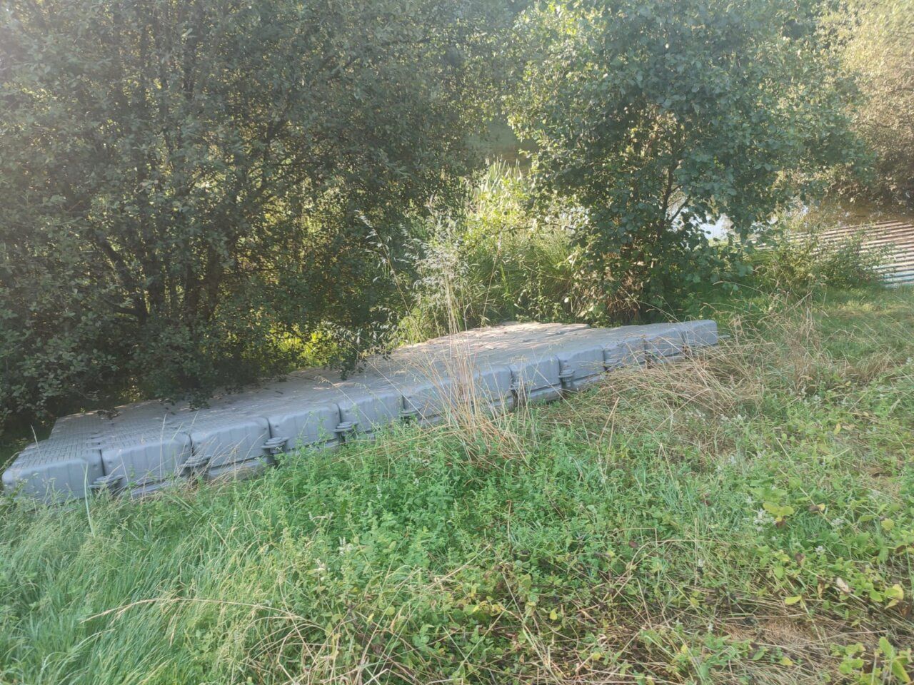 Embarcadero flotante retirado en el río Sil rodeado de vegetación