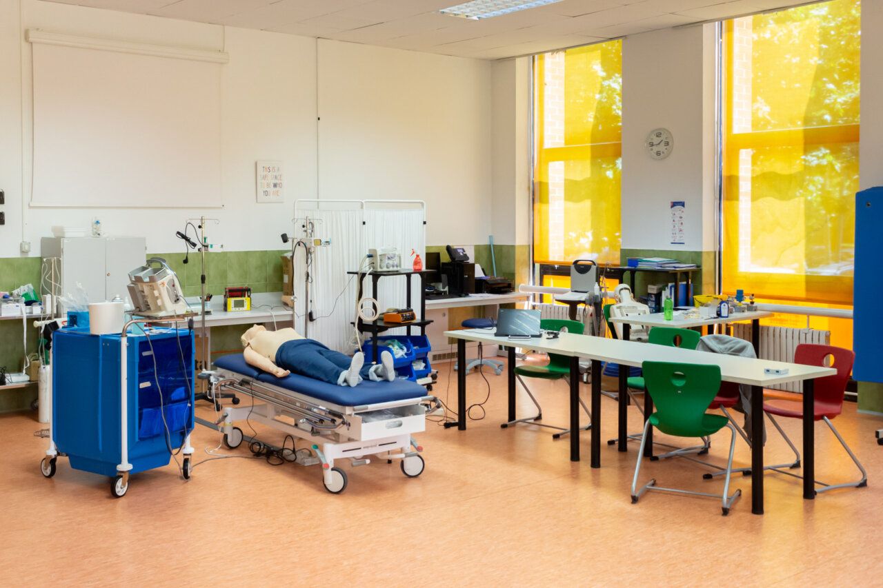 Sala de laboratorio de urgencias con equipo médico y maniquí