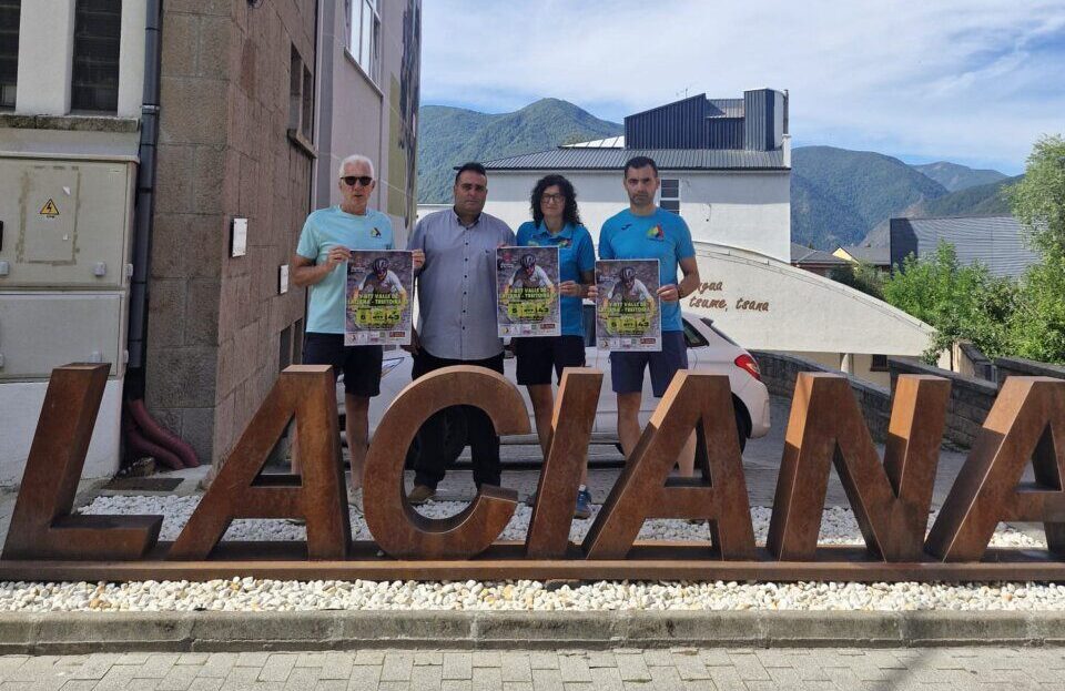 Cuatro personas sosteniendo carteles frente al letrero de Laciana