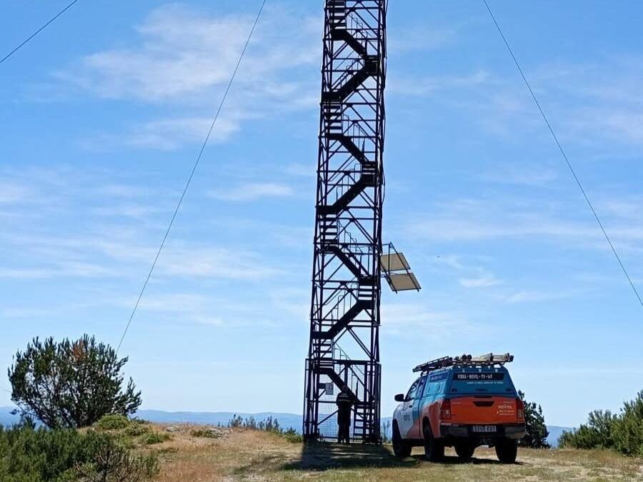 Torre de vigilancia forestal con un vehículo de Redytel en el campo