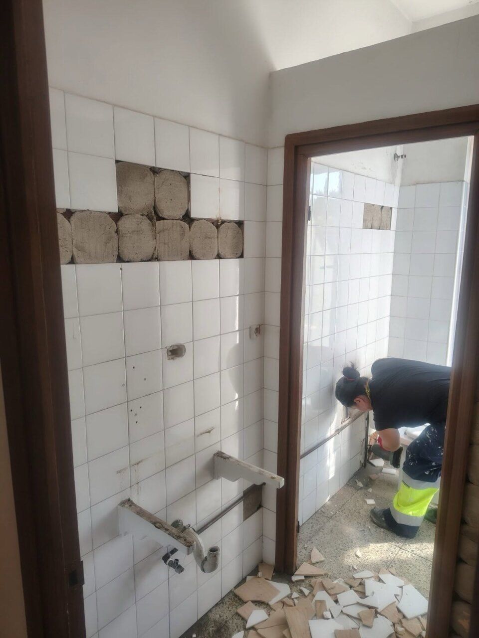 Trabajador realizando labores de albañilería en un baño en remodelación