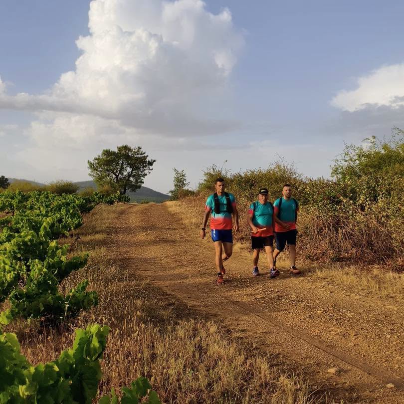 Tres personas caminando por un sendero en Arganza durante la marcha nocturna