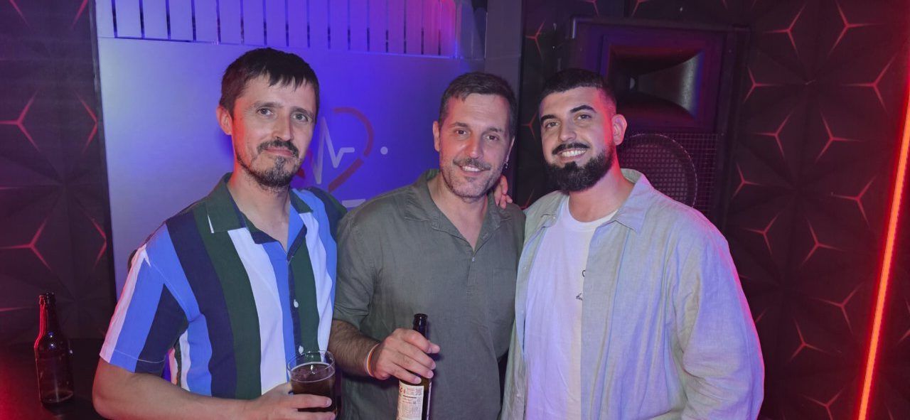 Tres hombres sonriendo en el Beats Dance Club durante una fiesta