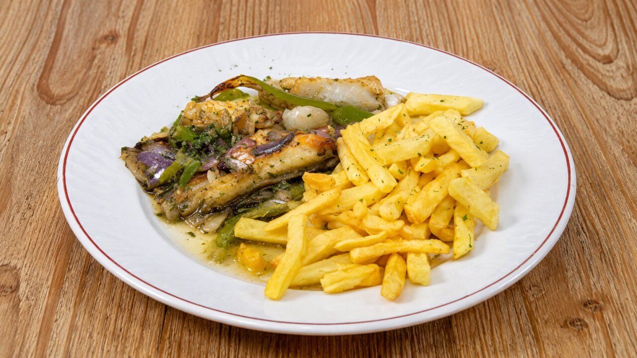 Plato del menú del día del Café Madrid en Ponferrada con pescado y patatas fritas.